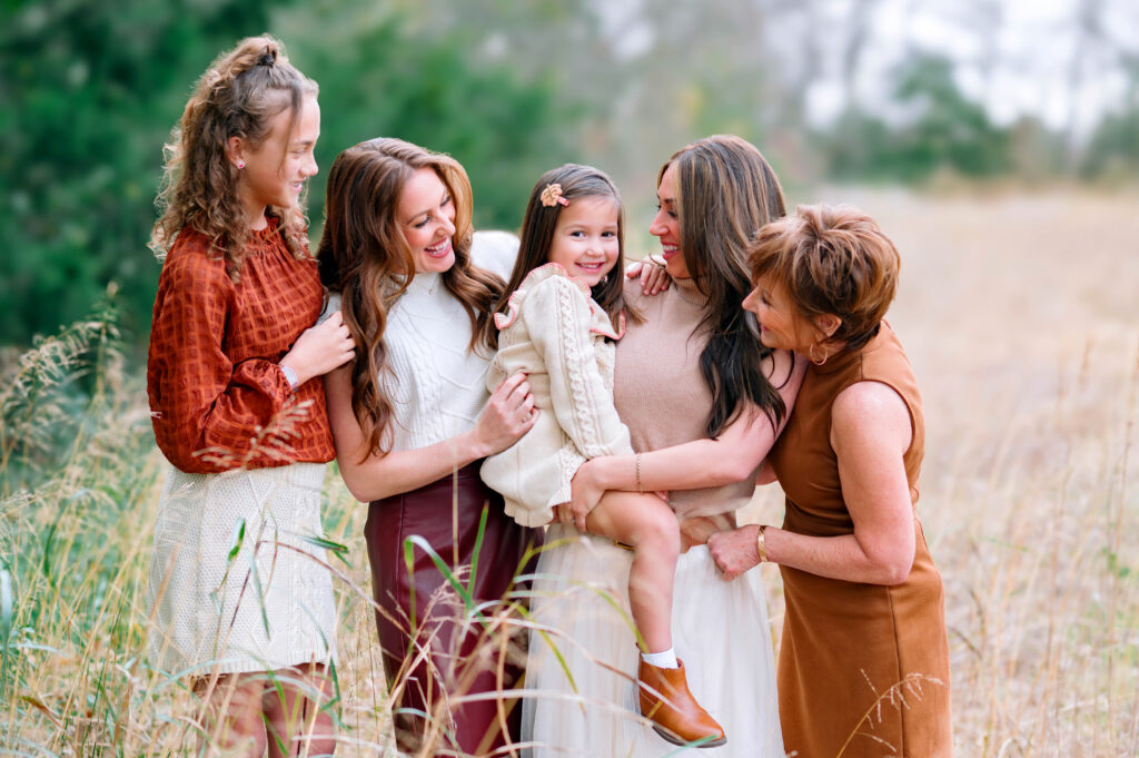 Extended family women and daughters laughing together during an outdoor fall family photo session at Erwin Park in McKinney.
