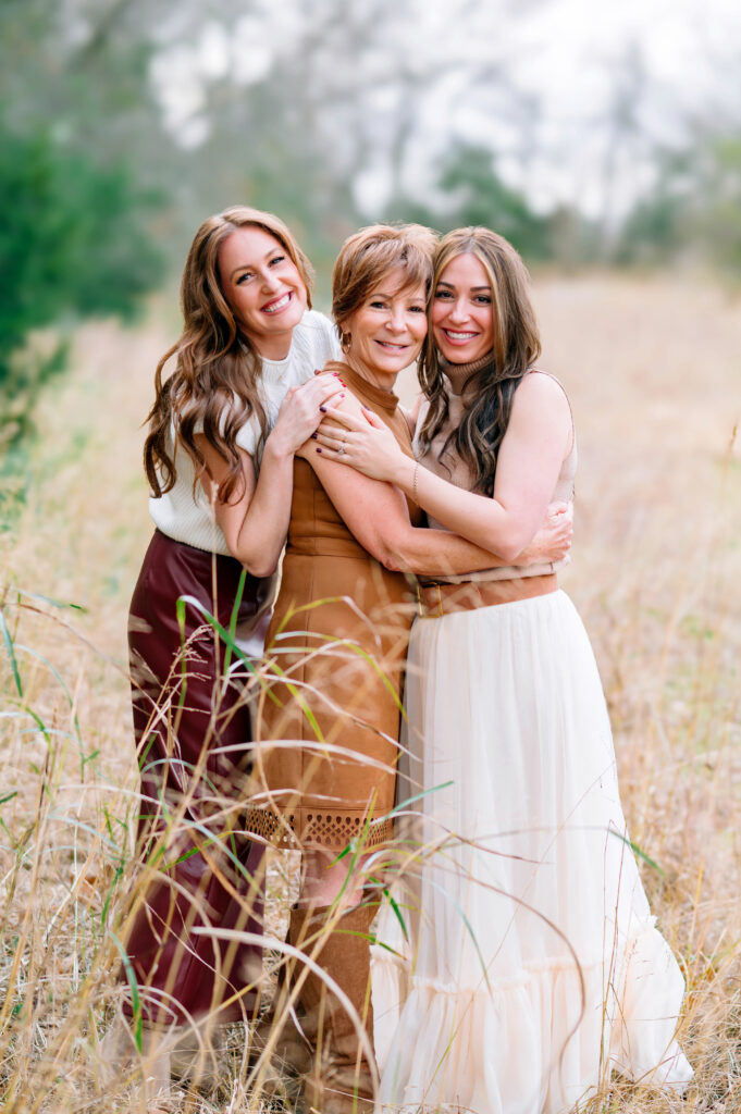 Three generations of women sharing a warm embrace during an outdoor extended family photo session at Erwin Park in McKinney.