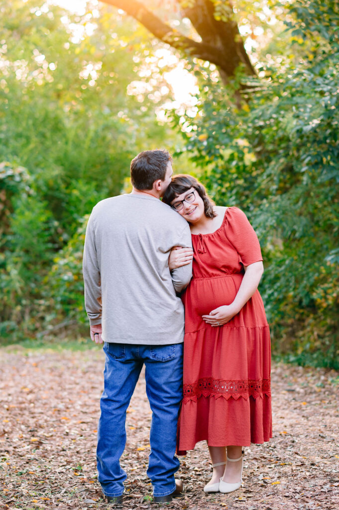 Couple embracing during McKinney maternity photos, capturing a tender moment before their family grows.