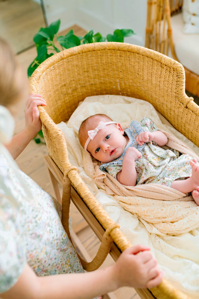 Baby girl in basket awake looking at camera with big sister look in at baby during newborn session in Murphy, Texas. 