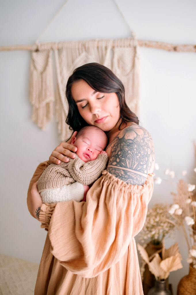 Baby asleep on moms chest in sweater during a newborn session in Prosper, Texas. 