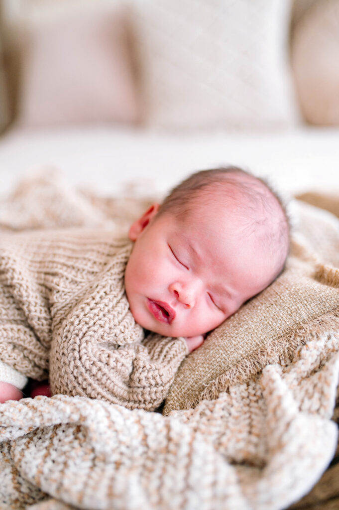 Baby asleep on pillow in sweater during a newborn session in Prosper, Texas. 