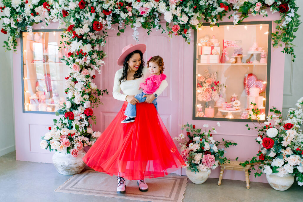 Mommy and me Valentine’s Mini Session in McKinney Texas with pink floral backdrop and red tulle skirt