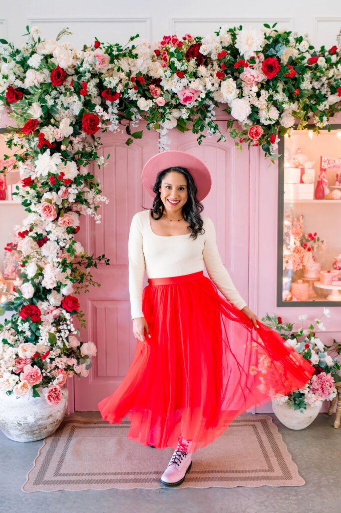 Valentine’s Mini Session portrait by McKinney Texas photographer with pink floral backdrop and red tulle skirt