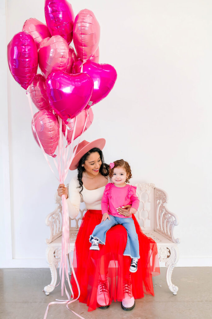 Mommy and me Valentine’s Mini Session in McKinney Texas with pink floral backdrop and red tulle skirt