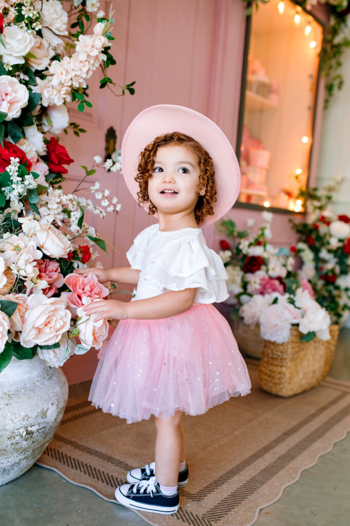 Little girl Valentine’s Mini Session in McKinney Texas with floral backdrop and pink tulle skirt