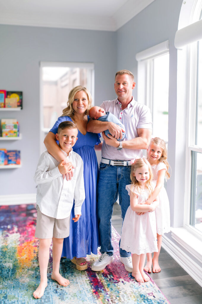 Family of 6 standing and posing during a newborn session in Plano, Texas. 