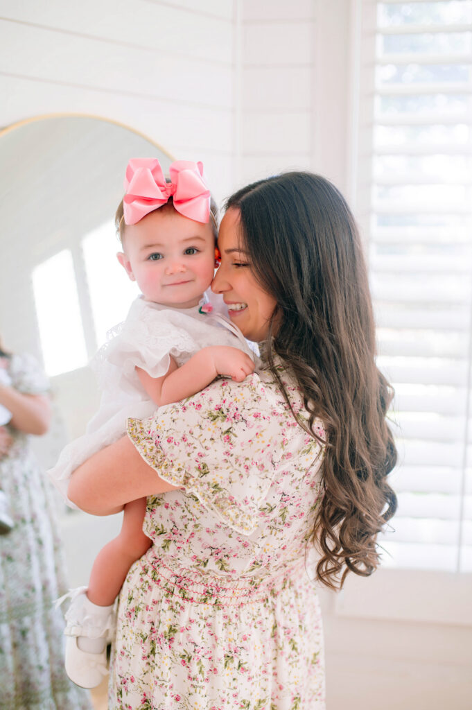 Mom holding and leaning into her daughter whilte standing in front of a mirror during a mommy and me portrait session with Jennifer L Kirk Photographer at the Beverly Harris House in Mckinney, Texas. 